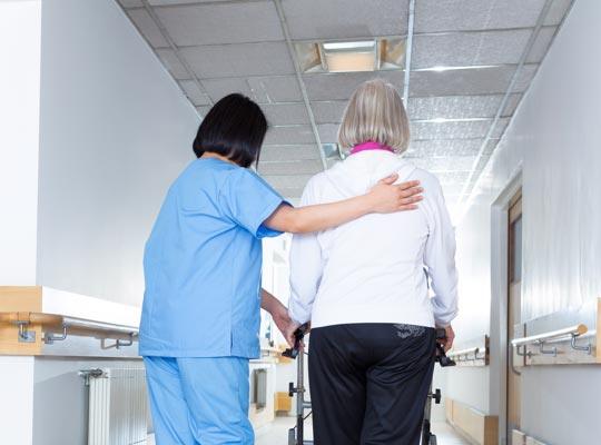 elderly woman walking in nursing home