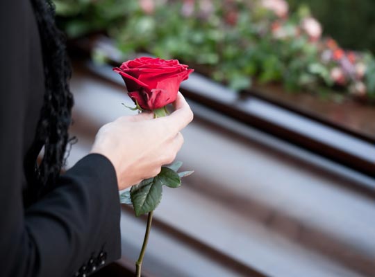 holding a rose at a funeral for someone who experienced wrongful death