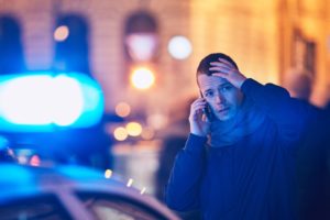 Distressed man making a call after a car accident