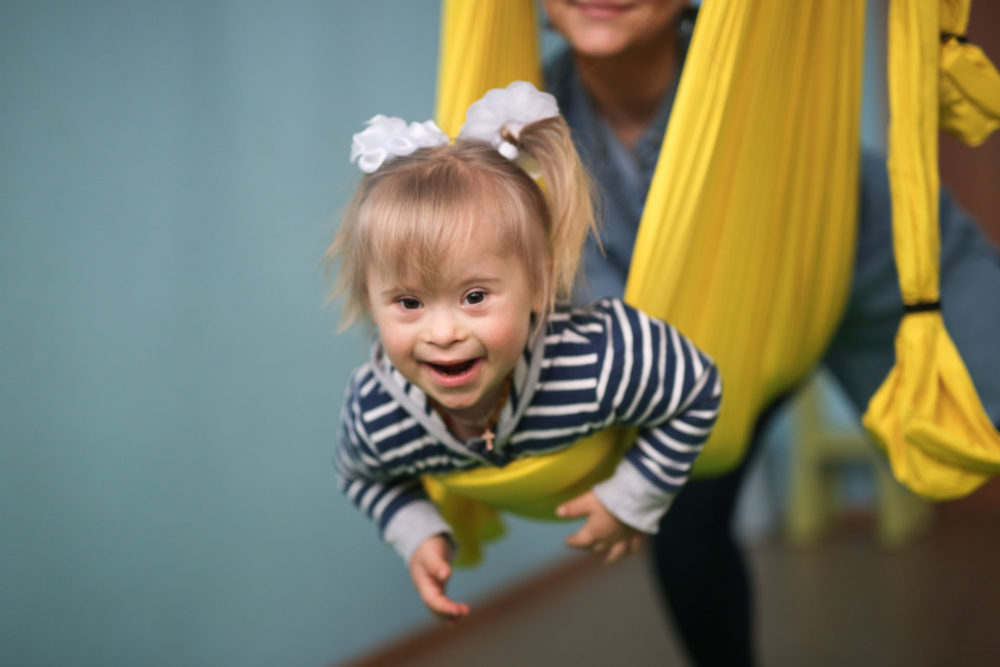 toddler with Cerebral palsy swinging in yellow sling