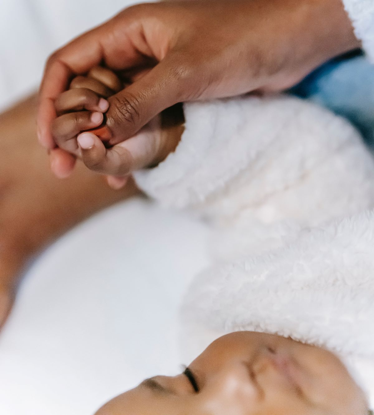 baby that was injured during birth and mom holding hands