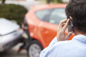 Young person on the phone after car accident