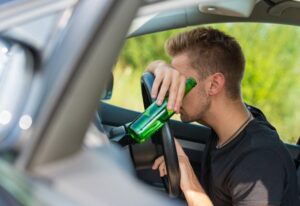 man holding a bottle, drunk driving