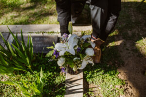family who lost a loved one puts a flower bouquet near a headstone