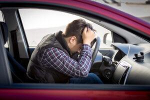 Image of a worried driver sitting in a car, illustrating fear and anxiety after experiencing a car accident.