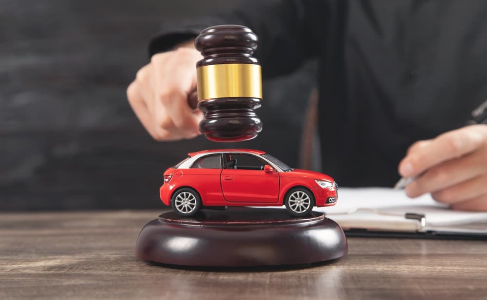 Judge striking the gavel over car.