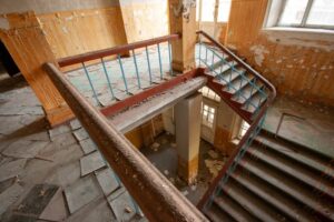 An abandoned building with a decaying staircase