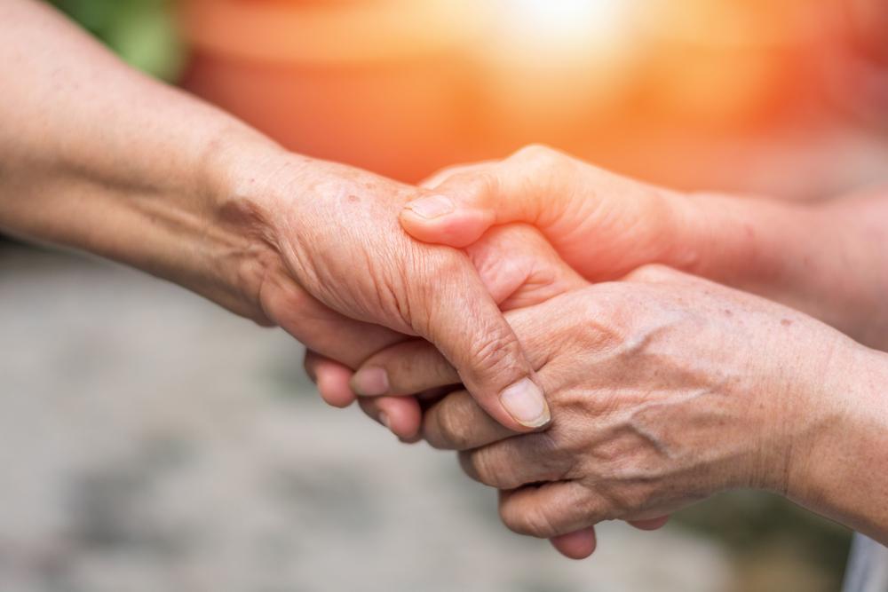 Close-up of hands being comforted, symbolizing support for nursing home abuse victims in Brooklyn.