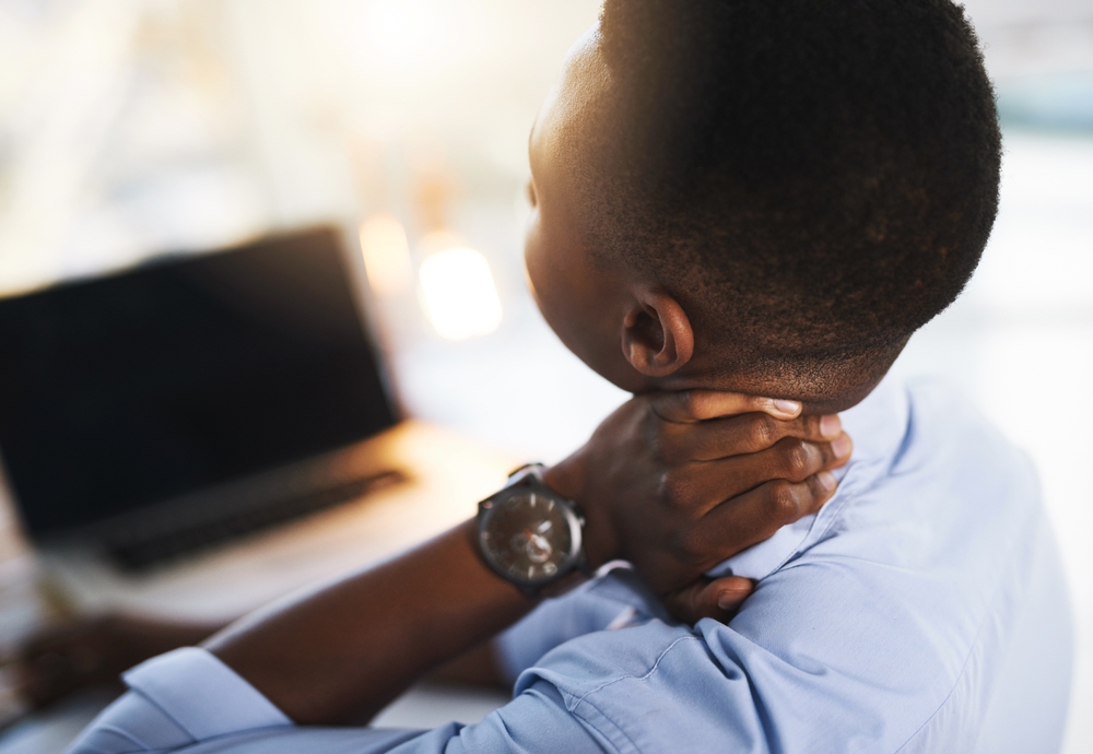 Man holding neck in pain due to chronic cervical spine injury or whiplash