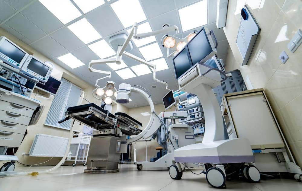 Empty hospital operating room with surgical tables and medical equipment